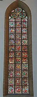 Buntglasfenster aus dem 14. Jahrhundert im Chor; im dreiteiligen Fenster findet sich links ganz unten sowie auch links in der Mitte das Vorbild der Lutherrose