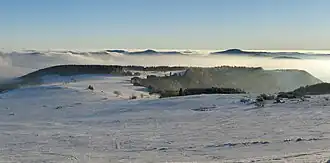 Blick vom Gipfel der Wasserkuppe südsüdwestwärts zum Eubeberg (Eube) mit Dammersfeldrücken am Horizont