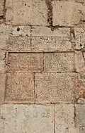 Lateinischer Totenspruch (1590) an der Nordecke der Kirche