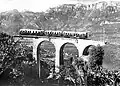 Elektrischer Zug der Fleimstalbahn auf dem Viadukt von Glen