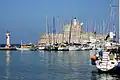 Yachten im Hafen Marina Mandraki mit der Festung Agios Nikolaos Pyrgos und dem Leuchtturm