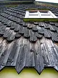 Holzschindelung an einem der wiederaufgebauten 14 Gebäude