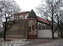 Gesamtansicht mit einem vor der Hauptfassade platzierten Hilfshäuschen