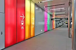 Als Teil des Wegeleitsystems architektonisch integrierte Kennfarbe der Ginza Line (Orange) und anderer Bahnlinien am Bahnhof Shibuya, Tokio