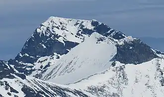Galdhøpiggen mit der markanten Westwand, links der Gipfel und die Hütte rechts daneben