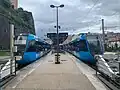 Tram-train-Züge in aktueller Farbgebung am überdachten Bahnsteig