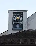 Schild an der Nordseite des Kamins der Hundskugel nach einem Relief