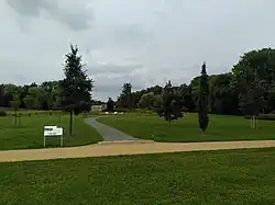 Einzelne Bäume im Vordergrund, im Hintergrund das Denkmal