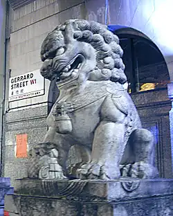 Ein Wächterlöwe in der Gerrard Street. Man beachte das zweisprachige englisch-chinesische Straßenschild im Hintergrund.