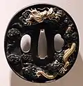 Jap. Tsuba: in der Mitte die Öffnung für die Klinge, daneben die Aufnahmen der Beimesser