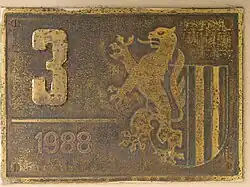 Plakette für Leipzig, mit Hausnummer und Jahreszahl sowie einem aus dem Leipziger Wappen steigenden Meißner Löwen neben den Landsberger Pfählen (vermutlich Messingguss).