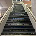 Treppe zur Besucherterrasse, mit historischen Meilensteinen.