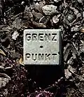 Grenzzeichen aus Beton mit Loch und Beschriftung