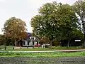Haltestelle in Groß Ippener mit ehemaligem Gasthof im Hintergrund