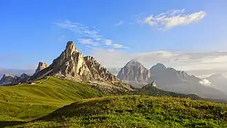 Die Süd- und Ostwand der Ra Gusela im Morgenlicht vom Passo di Giau. Links der Monte Averau (2649 m) und rechts die Tofana di Rozes (3225 m) und die Tofana di Mezzo (3244 m).