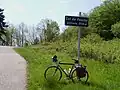 Reiserad mit Gepäck am Passschild