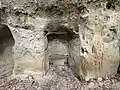 Zahlreiche Gravierungen im abblätternden Sandstein