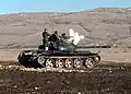 Angehörige der 2.&nbsp;Garde-Brigade feuern während einer Militärübung aus einem 12,7-mm-Maschinengewehr eines T-55-Kampfpanzers.