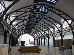 Eine Halle mit breiten Stahlträgern im Stil einer Bahnhofshalle