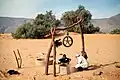 Zwei junge Tuareg beim Brunnen Hassi Dagalouche. Hinten Tamarisken-Büsche und der Rücken des Bergzugs In Tirhaouine