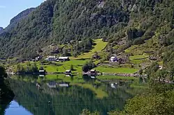 Foto vereinzelter Häusern in einem steilen Terrain an einem Gewässer