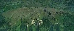 Ein langes, leicht vergletschertes Bergmassiv, umgeben von Vegetation