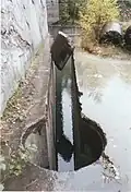 Bohrloch (Durchmesser ca. 40&nbsp;cm) für die absenkbare Umlenkrolle und erster Schnitt in einem Kalksteinbruch (historische Technologie mit Stahlseil)