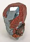 Hämatit, von rotem Andradit überwachsen aus der „Wessels Mine“, Hotazel, Kalahari Manganfeld, Nordkap, Südafrika (Größe: 4,2&nbsp;cm&nbsp;×&nbsp;2,8&nbsp;cm&nbsp;×&nbsp;2,4&nbsp;cm)