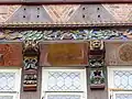 Deckenbalkenkopf mit figürlicher Schnitzerei, ergänzt durch beschnitzte Knaggen, Stockschwelle und bemalte Füllhölzer (Knochenhaueramtshaus Hildesheim, 16. Jahrhundert, rekonstruiert)