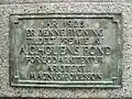 Houens fonds Bronzeplakette für Magnus Poulsson für Det Forenede Dampskibs-Selskab, Karl Johans gate 1, Oslo