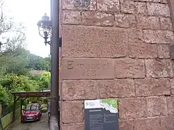 Denkmalgeschützter Inschriftstein (oben im Bild)