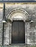 Nordportal mit dem romanischen Tympanon der ursprünglichen Kirche