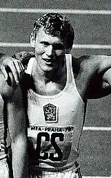 Das Schwarz-Weiß-Foto zeigt Josef Lomický nach dem Rennen. Er trägt ein weißes Trikot.
