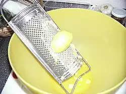 Kartoffelreibe mit geriebener Kartoffel, der sogenannte „Schab“ oder „Reibicht“, gelangt in die Schüssel, später wird es von der Kartoffelstärke getrennt