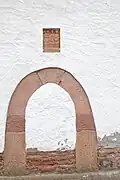Vermauerter Torbogen mit Darstellung der drei Parzen