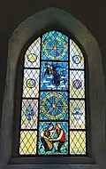 Das Vrenelifenster in der Kirche. Gelesen wird es von unten nach oben: das liebende Paar, das intakte Mühlrad, Vrenelis Tod, das gebrochene Rad