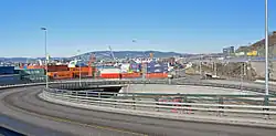 Foto eines Hafengebiets mit vielen Containern, im Vordergrund eine Straße
