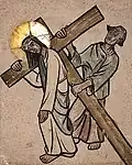 V. Station: Simon von Cyrene hilft Jesus das Kreuz tragen.
