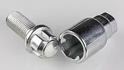 Kugelbund-Felgenschloss und zugehöriger Schlüssel (Adapter), letzterer mit 17&nbsp;mm- und 19&nbsp;mm-Sechskant