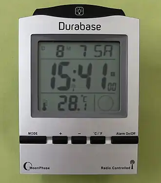 Wecker mit Flüssigkristalldigitalanzeige. Neben der über Funk synchronisierten Zeit-, Datum- und Mondphasenanzeige auch Temperaturangabe.