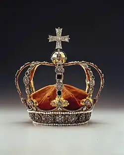 Reichverzierte Krone. Auf der Spitze ist ein Kreuz zu sehen.