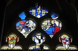 Maßwerk mit der Verkündigung des Herrn, darüber der Kopf des heiligen Claudius, und darunter die Wappen der Stifterfamilie