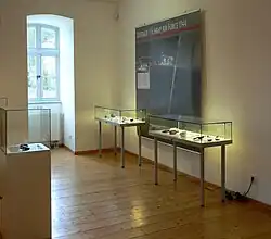 Ausstellung in den historischen Kuranlagen Bad Rehburg, hier alliiertes Luftbild des Lagers und Fundstücke der Ausgrabung, 2025