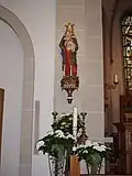 Im Mai geschmückte Marienstatue am linken Chorpfeiler