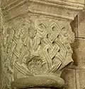 Kapitell mit Flechtband und Pinienzapfen
