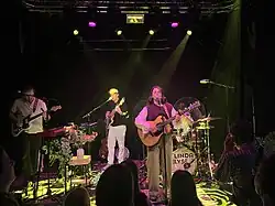 Bild von Linda Elys auf der Bühne mit Band im Hintergrund.