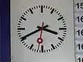 Uhr in Fallblattanzeigetafel und spitzen Zeigern