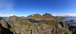 Foto einer felsigen Insel mit einem Leuchtturm und einem weißen Haus darauf