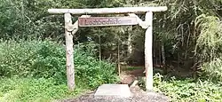 Eingang als Holztorbogen von der Bergseite aus Richtung Hülsa