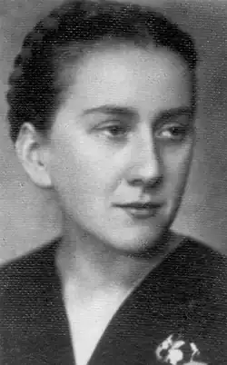 eine junge, schöne Frau mit regelmäßigen Gesichtszügen, schmaler Nase, lächelnd, das Haar ist nach hinten zurückgebunden